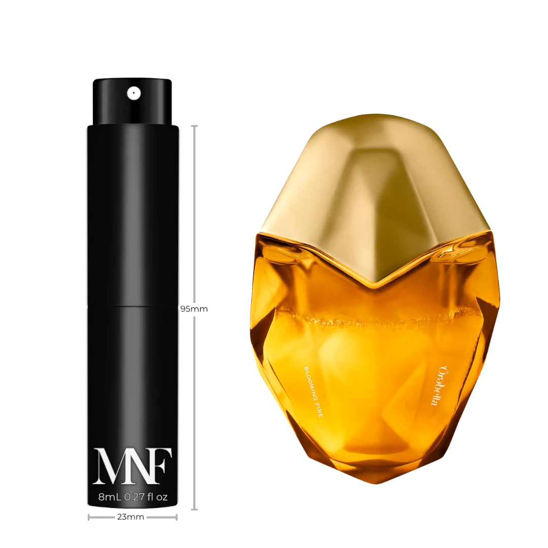 My Next Fragrance 8mL travel spray atomizer next to an Ôrəbella Blooming Fire perfume bottle on a black background.